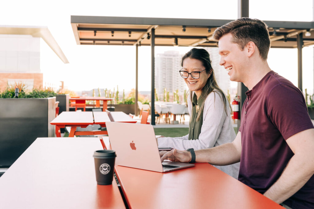 AI Search Optimization: Image of people working on a laptop at a table.