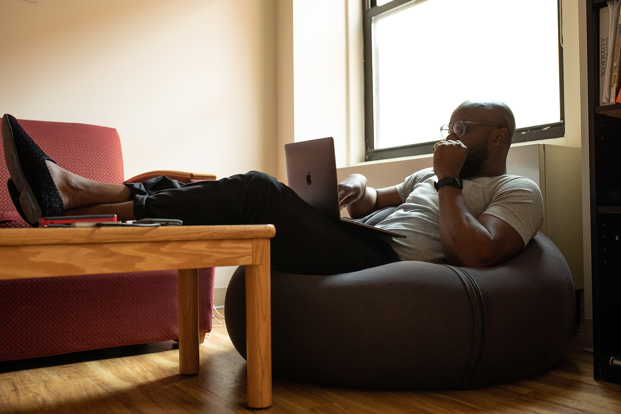 Man on bean bag working on SEO on computer